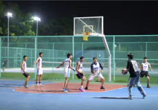 Students playing basketball at night