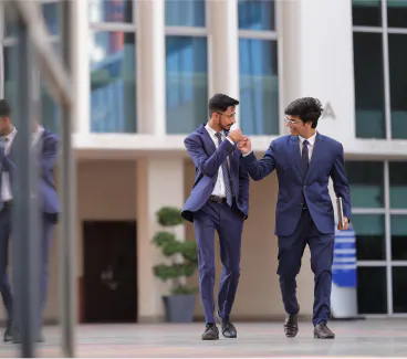 Two students in suits walking together